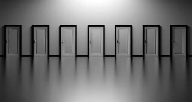 Sieben identisch wirkende kalte Türen, unterschiedlich beleuchtet.