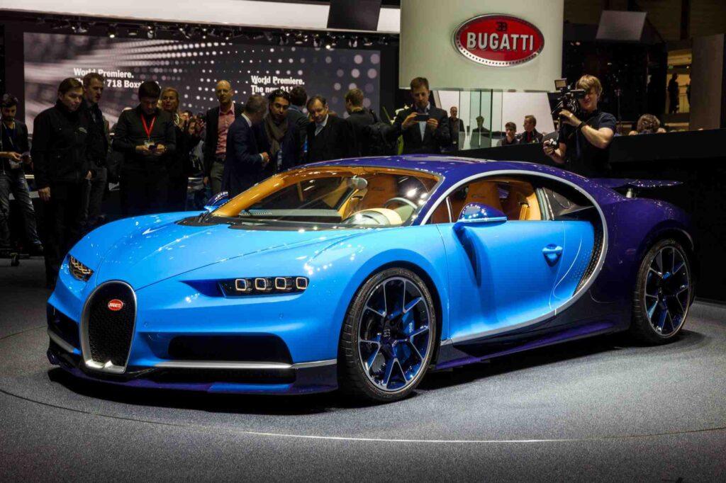 Blauer Bugatti Chiron auf einer Automesse in schräger Frontansicht als Beispiel für die Versicherung eines exklusiven Supersportwagens.