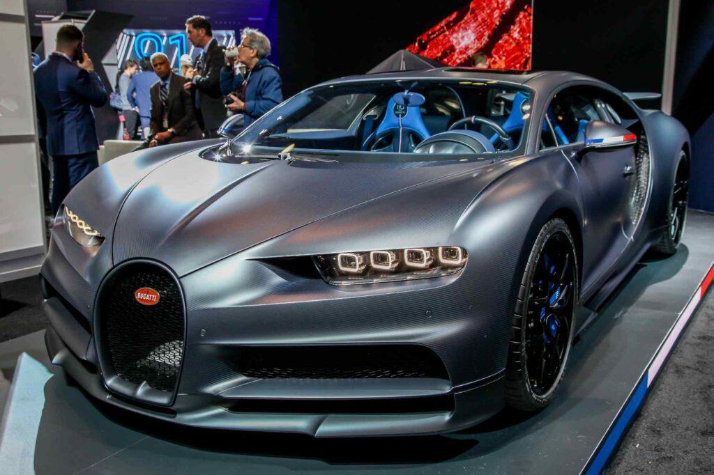 Grauer Bugatti Chiron mit Carbon-Karosserie in schräger Frontansicht als Symbol für eine hochwertige Kfz-Versicherung für Supersportwagen.